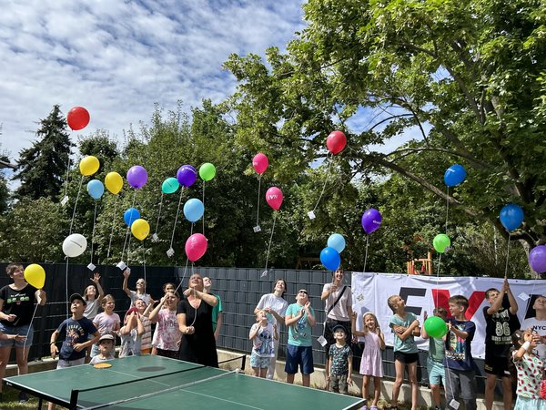 Eine Gruppe Kinder lässt Luftballons steigen