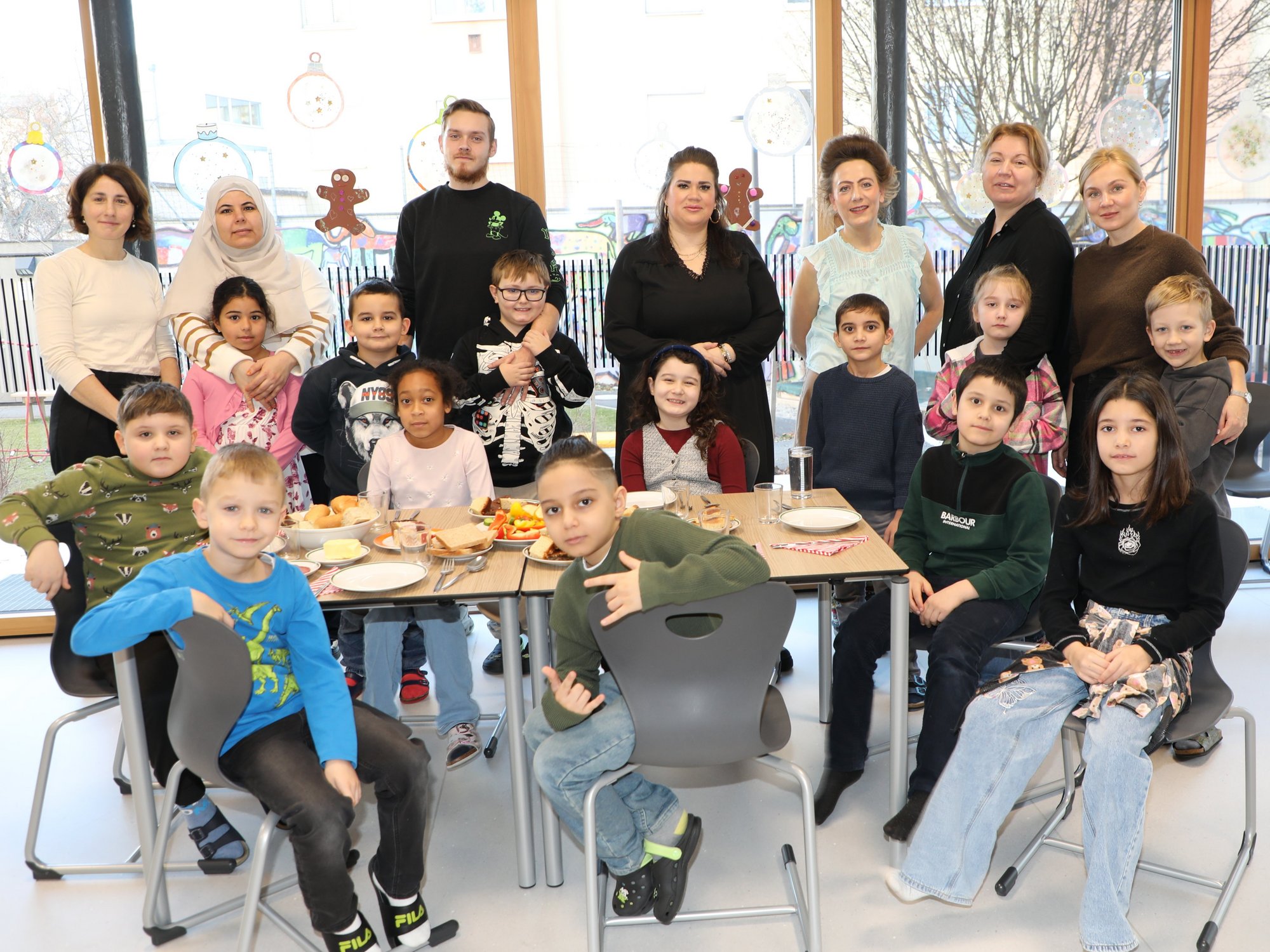 Lehrerin Caroline Dorn und ihre Kollegin Andrea Rametsteiner-Aigner mit den Schüler:innen und Eltern der Klasse 2a beim interkulturellen Neujahrsfrühstück in der Volksschule Hafnerplatz.