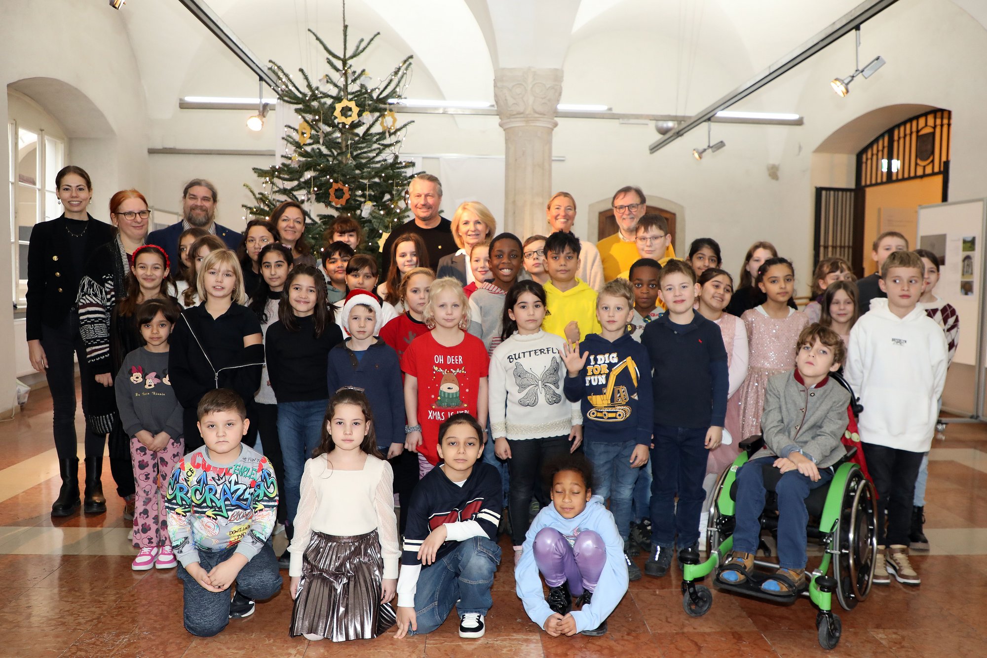 Gruppenbild des Kinderchores mit seinen beiden Leiterinnen, der Schuldirektorin und vier politischen Vertretern der Stadt