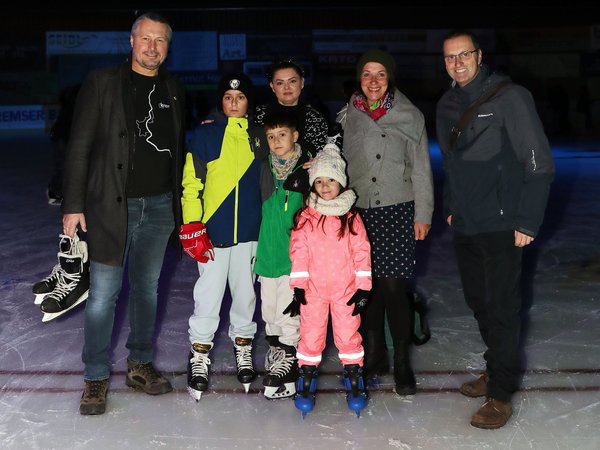 Gruppenfoto von Vertretern der Stadt und eine Familie mit drei Kindern auf der Kunsteisbahn