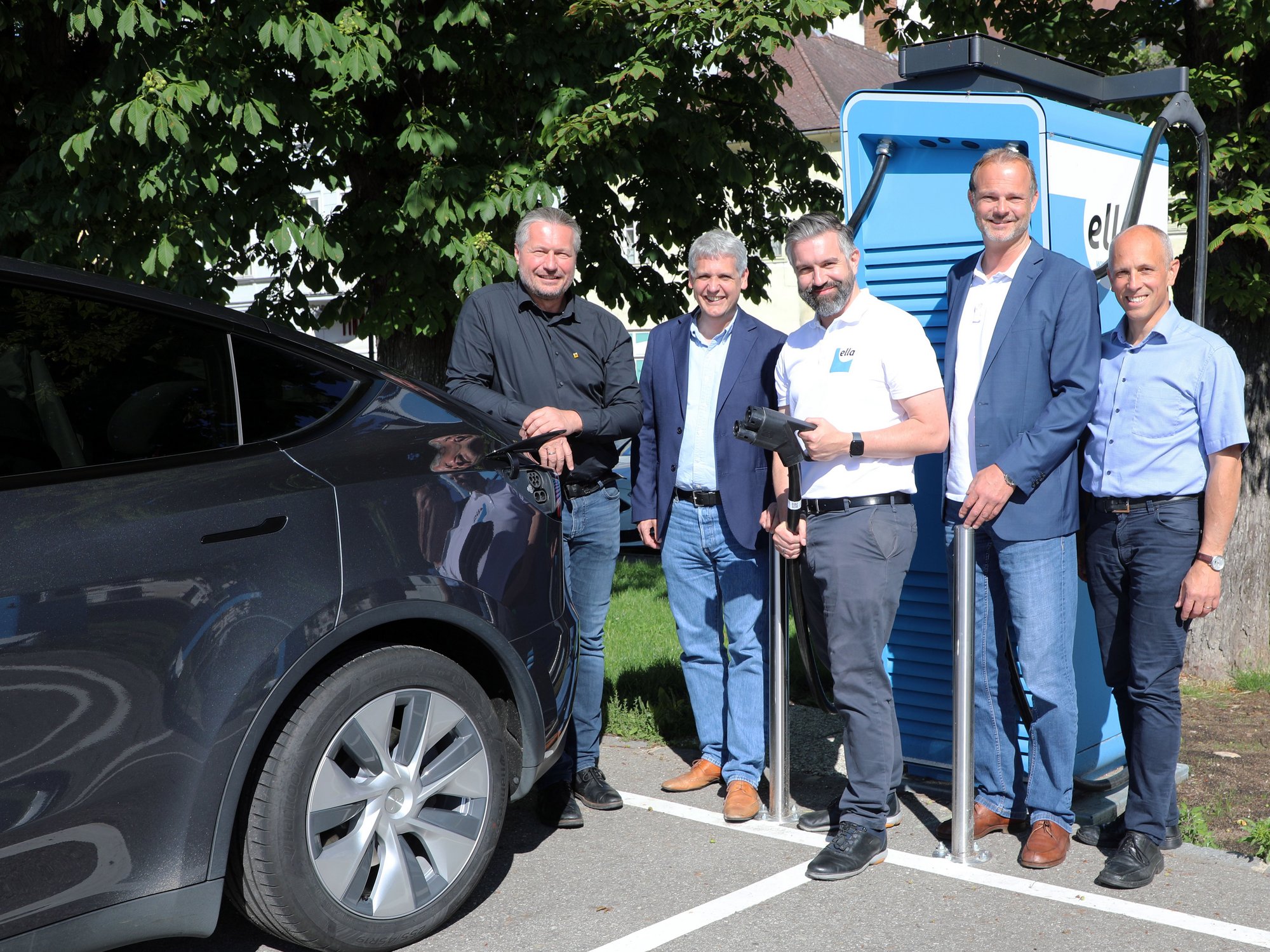 Fünf Vertreter von Stadt Krems und Firma ELLA samt Auto vor der neuen E-Tankstelle