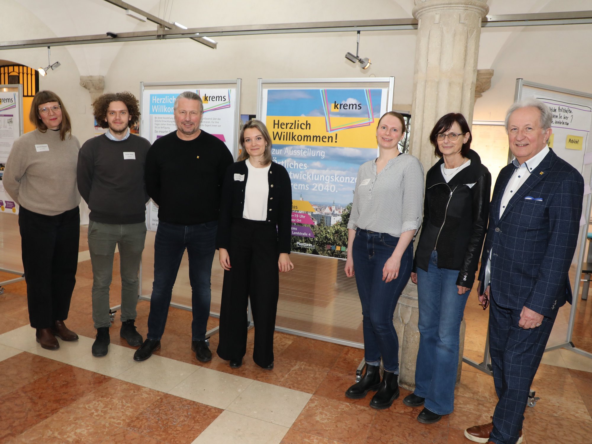 Sieben Vertreter aus Stadtpolitik, Magistrat und Planungsbüros vor einer Ausstellungswand im Rathausfoyer