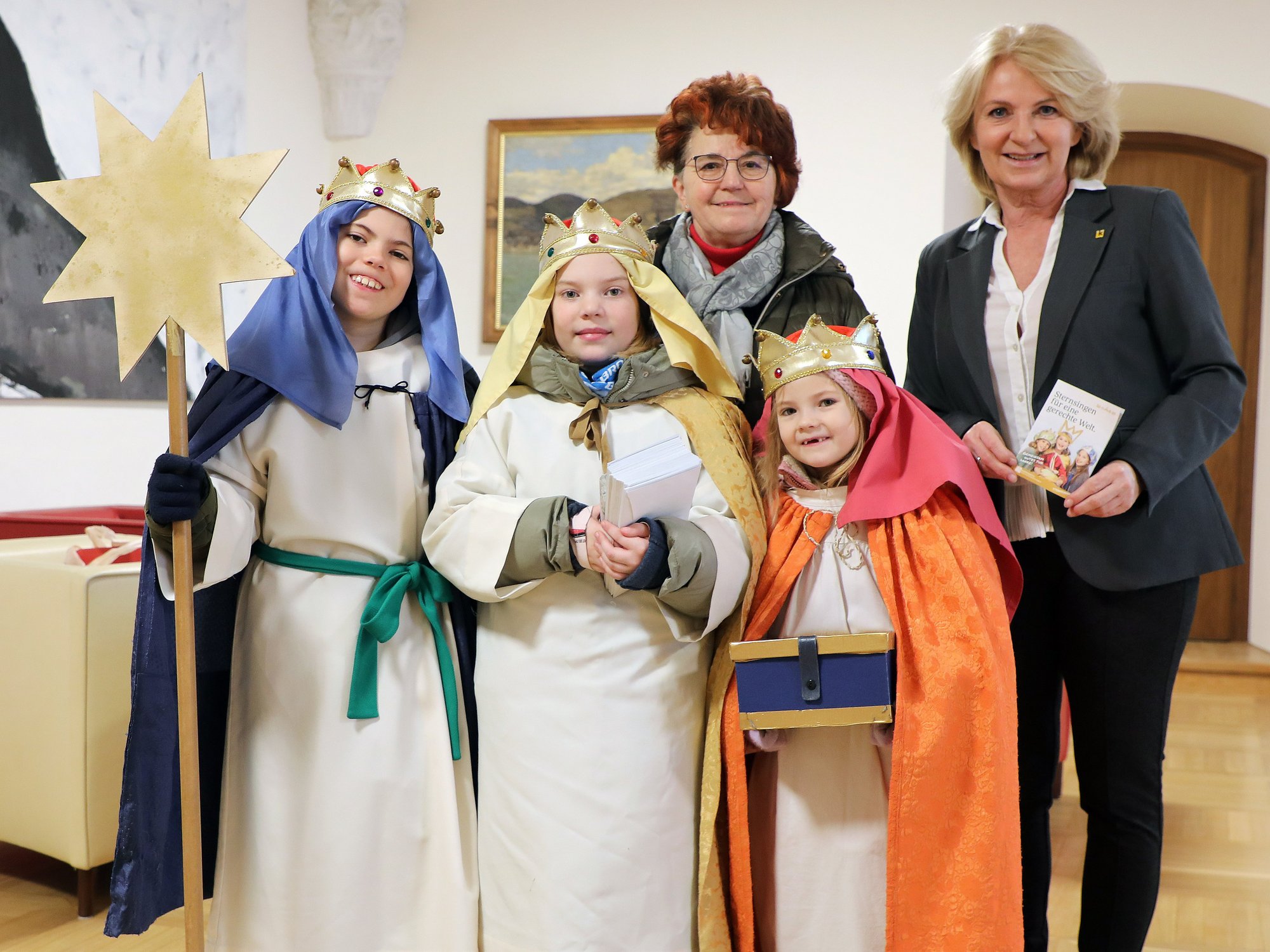 Drei Sternsinger mit Begleiterin und Vizebürgermeisterin Eva Hollerer im Rathaus